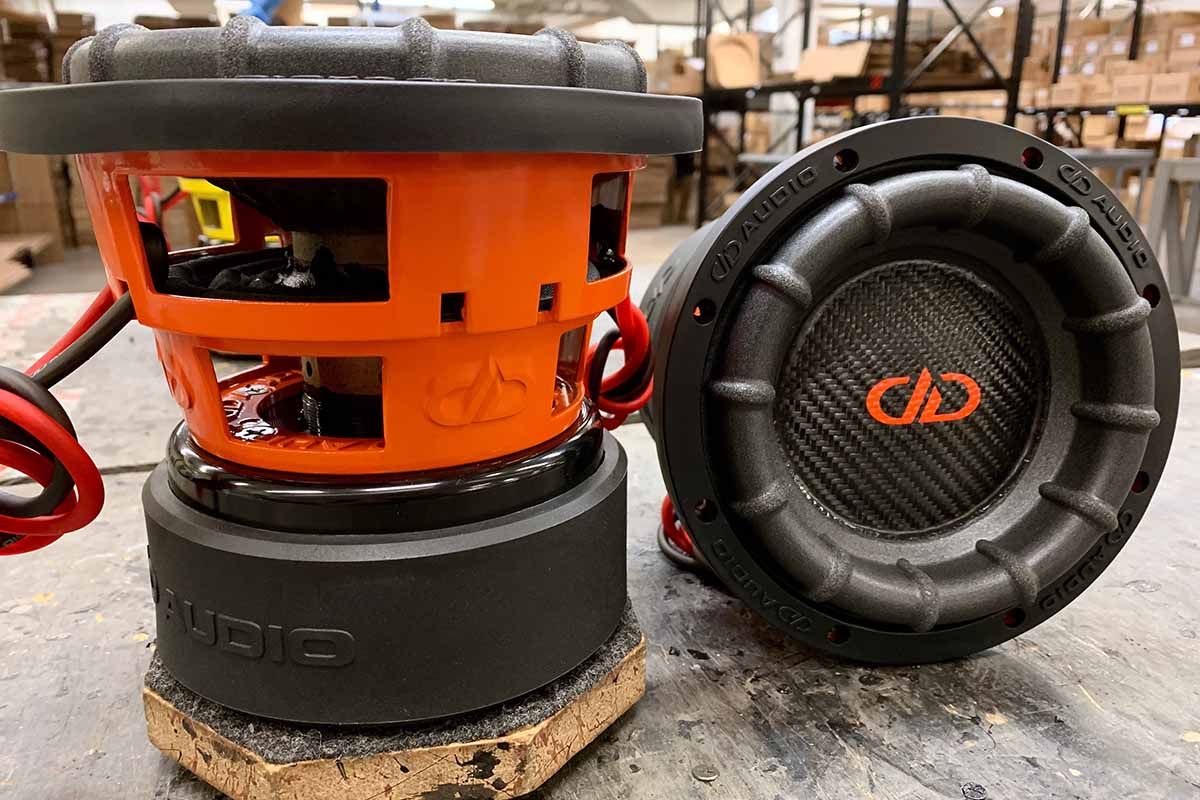 Two USA Made subwoofers with orange powder coat baskets, black carbon fiber dust caps, orange DDA logos